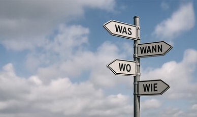 Wegweiser aus Metall mit 4 Pfeilen: was, wer, wann, wie?