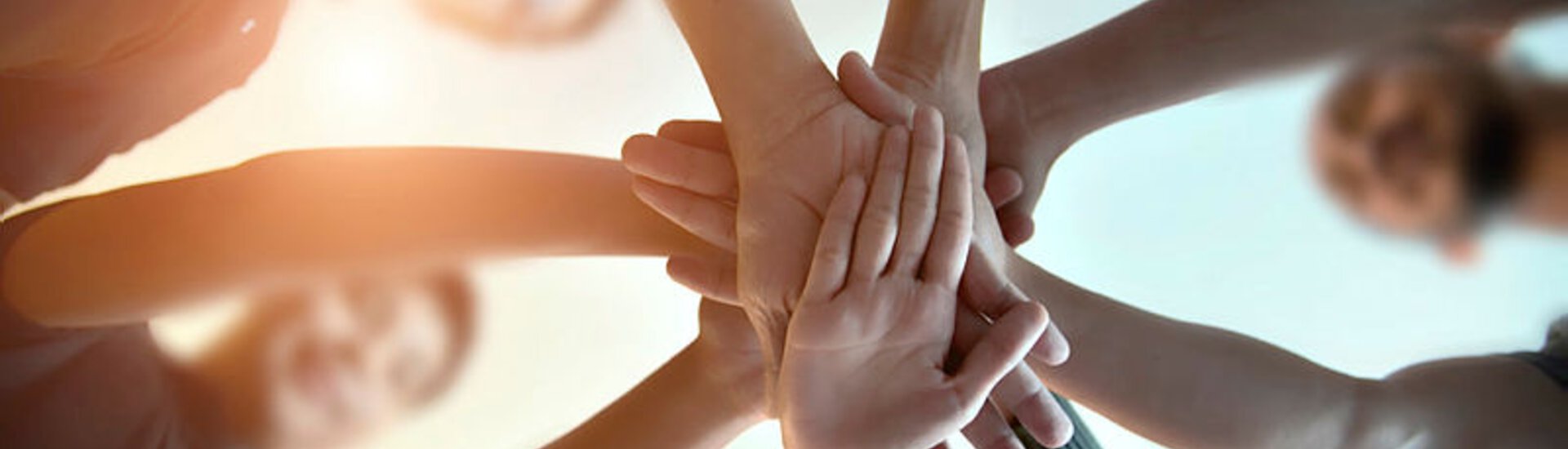 Mehrere Hände eines Teams berühren sich in der Mitte