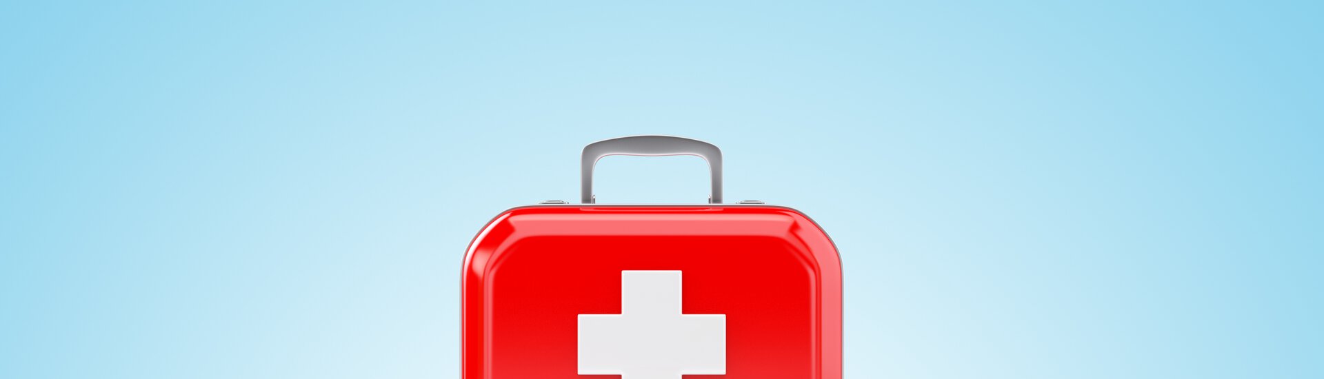 Roter Erste-Hilfe-Kasten vor blauem Hintergrund