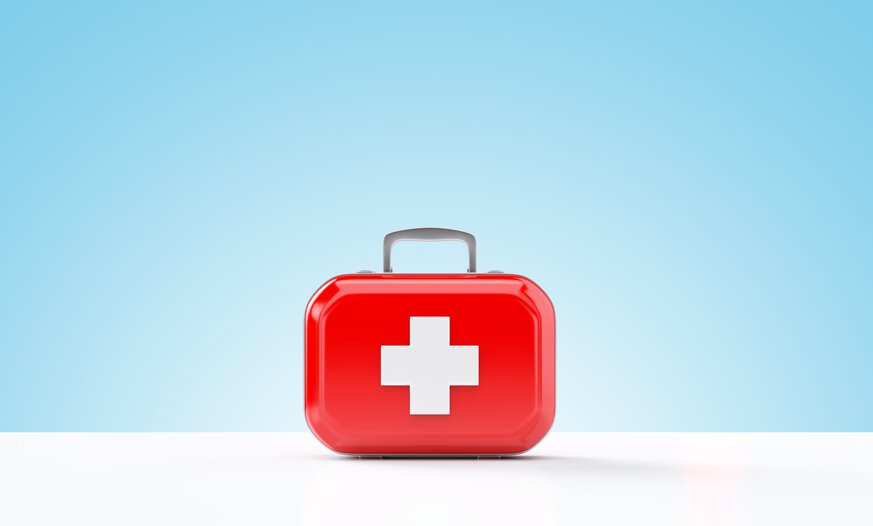 Roter Erste-Hilfe-Kasten vor blauem Hintergrund