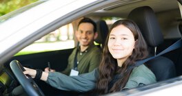 Junge Frau sitzt mit Mann im Auto