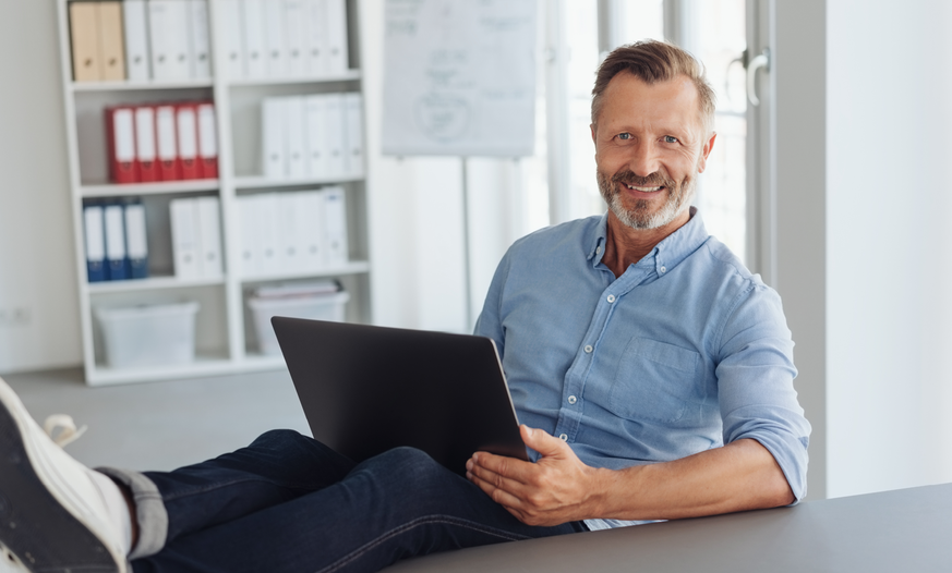 Mann mit Laptop auf dem Schoß