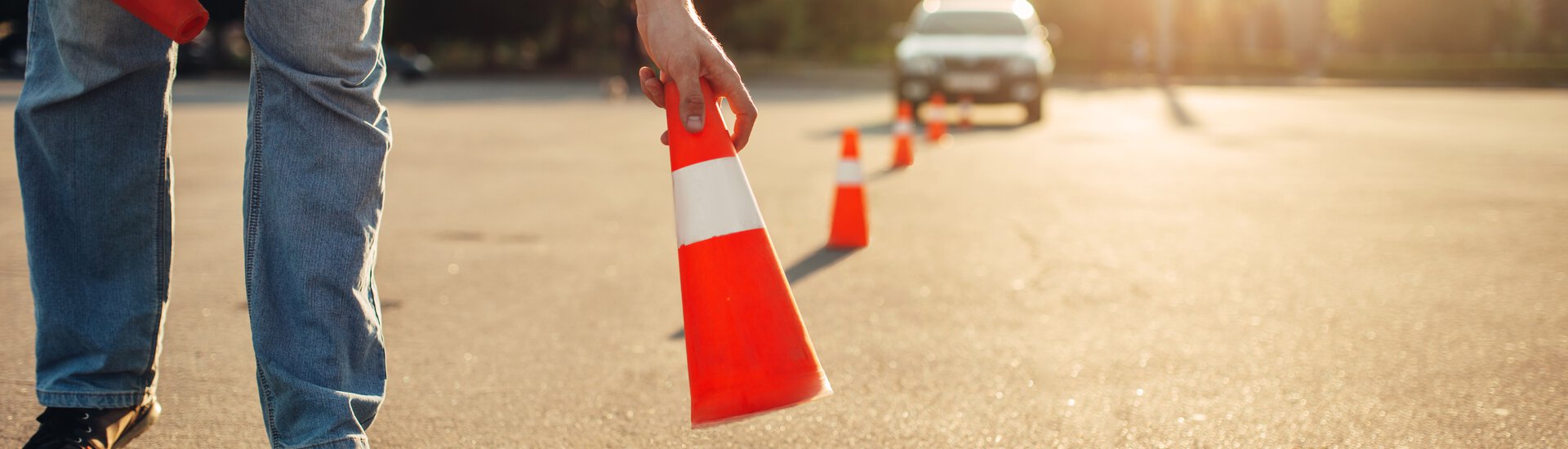 Mann stellt Verkehrskegel auf die Straße