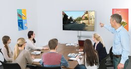 Fahrschüler*innen und Fahrlehrer betrachten Fernseher mit Drivers Cam Lektion 