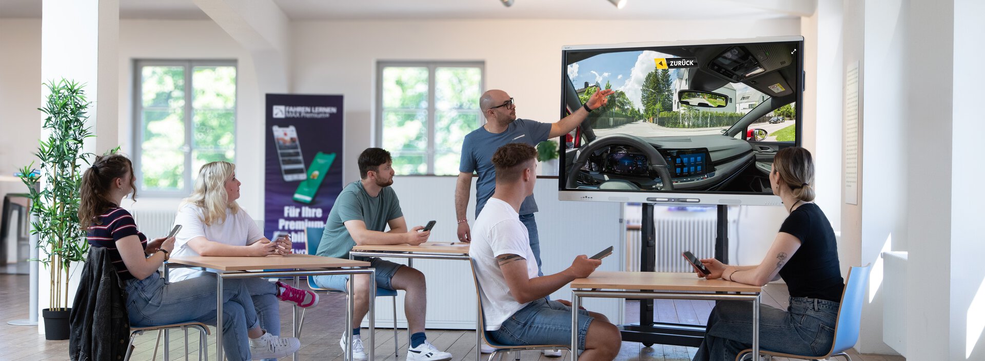 Schüler*innen und Fahrlehrer in Theorieunterricht in Fahrschule