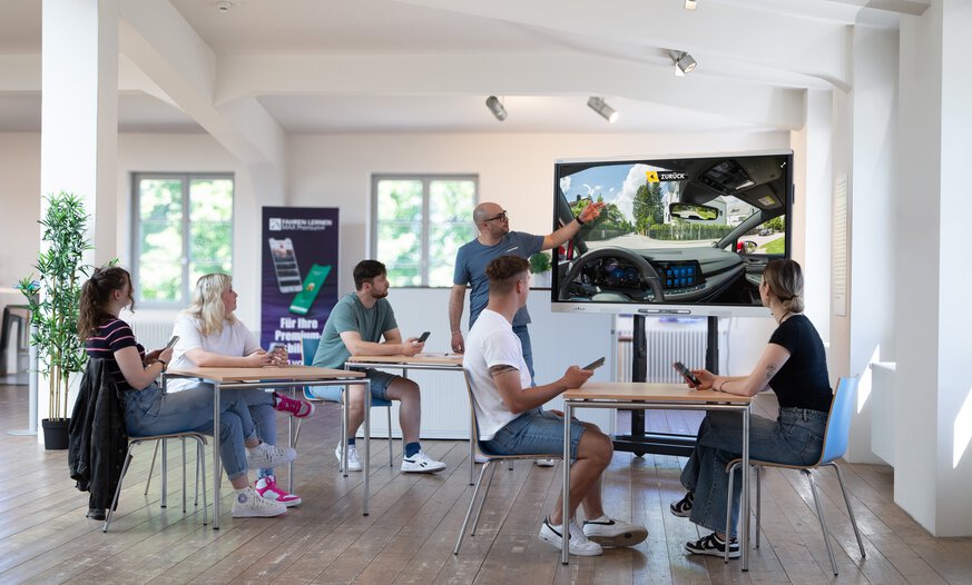 Moderner Theorieunterricht mit der PC Professional Cloud Schüler*innen und Fahrlehrer in Theorieunterricht in Fahrschule