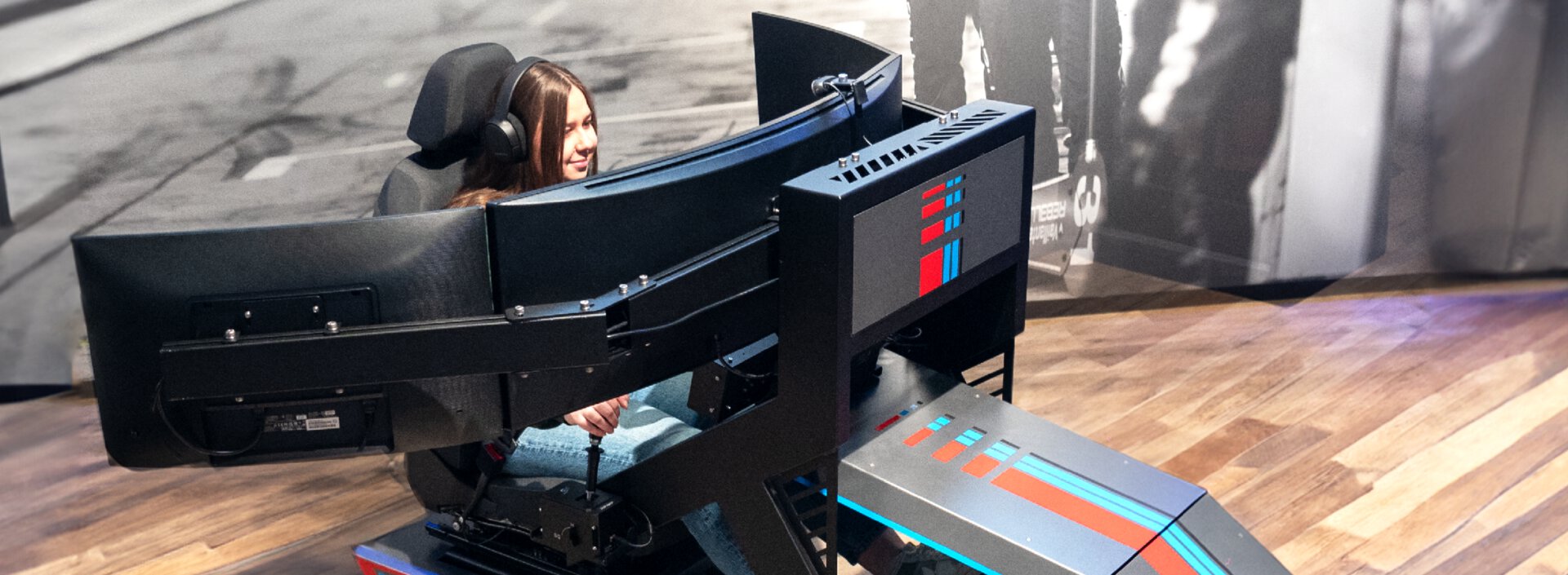 Junger Mann sitzt in Fahrsimulator
